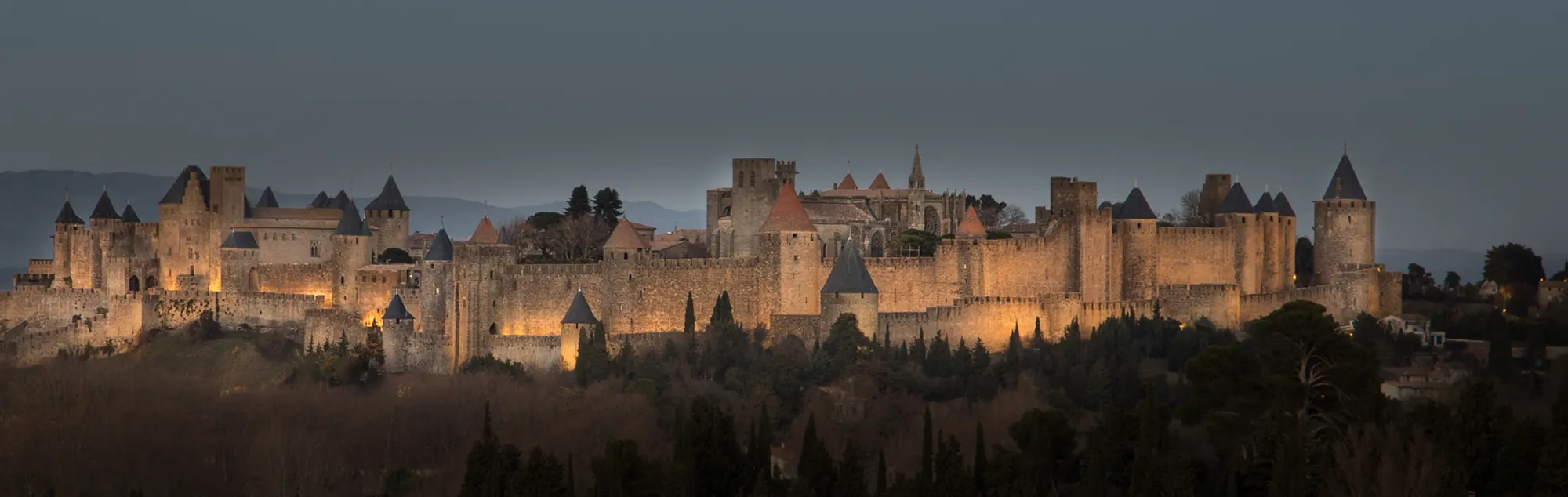 De Cité van Carcassonne ’s avonds verlicht, van een afstand gezien.