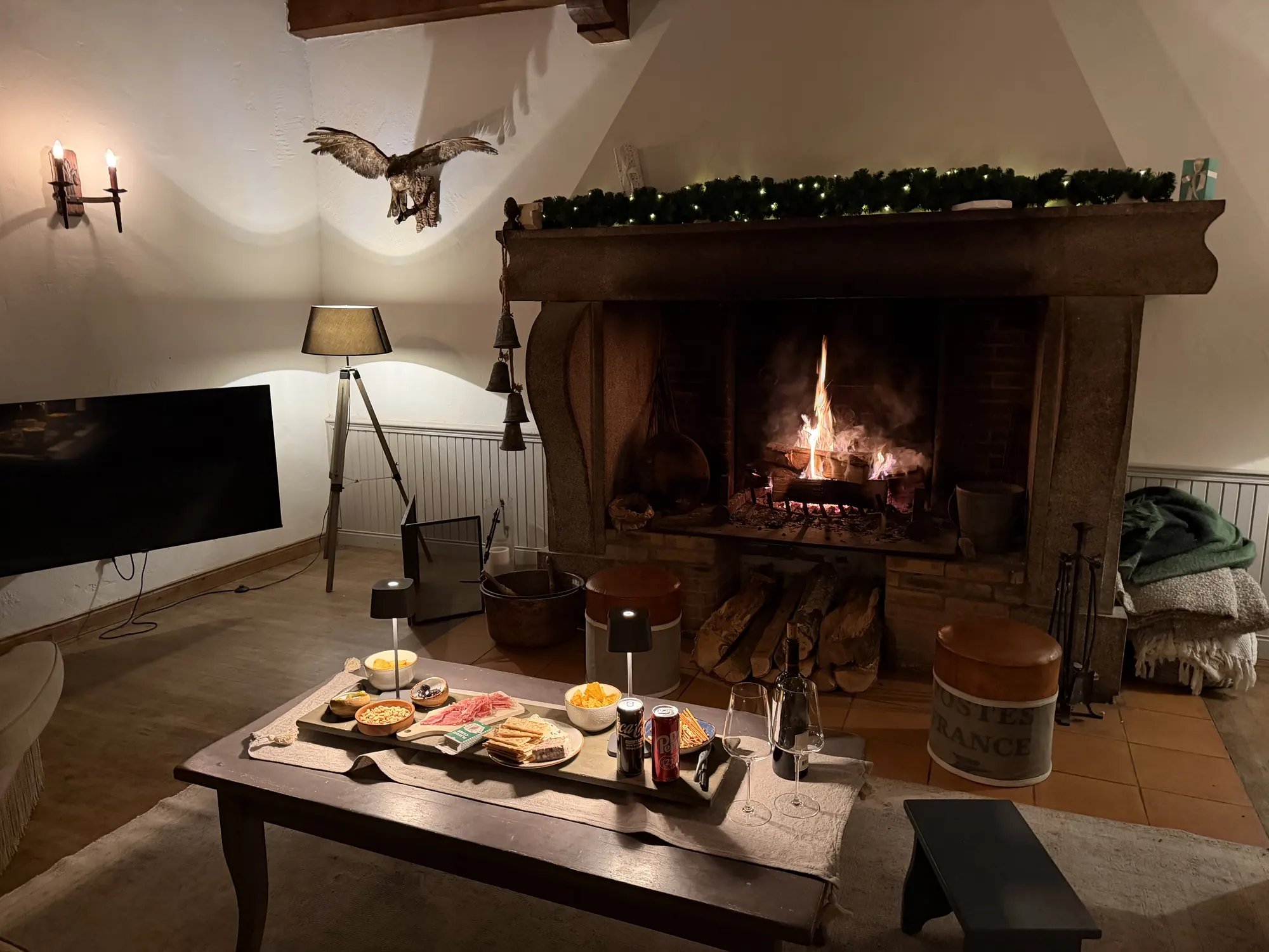 De open haard brandt, met een lage tafel ervoor.
