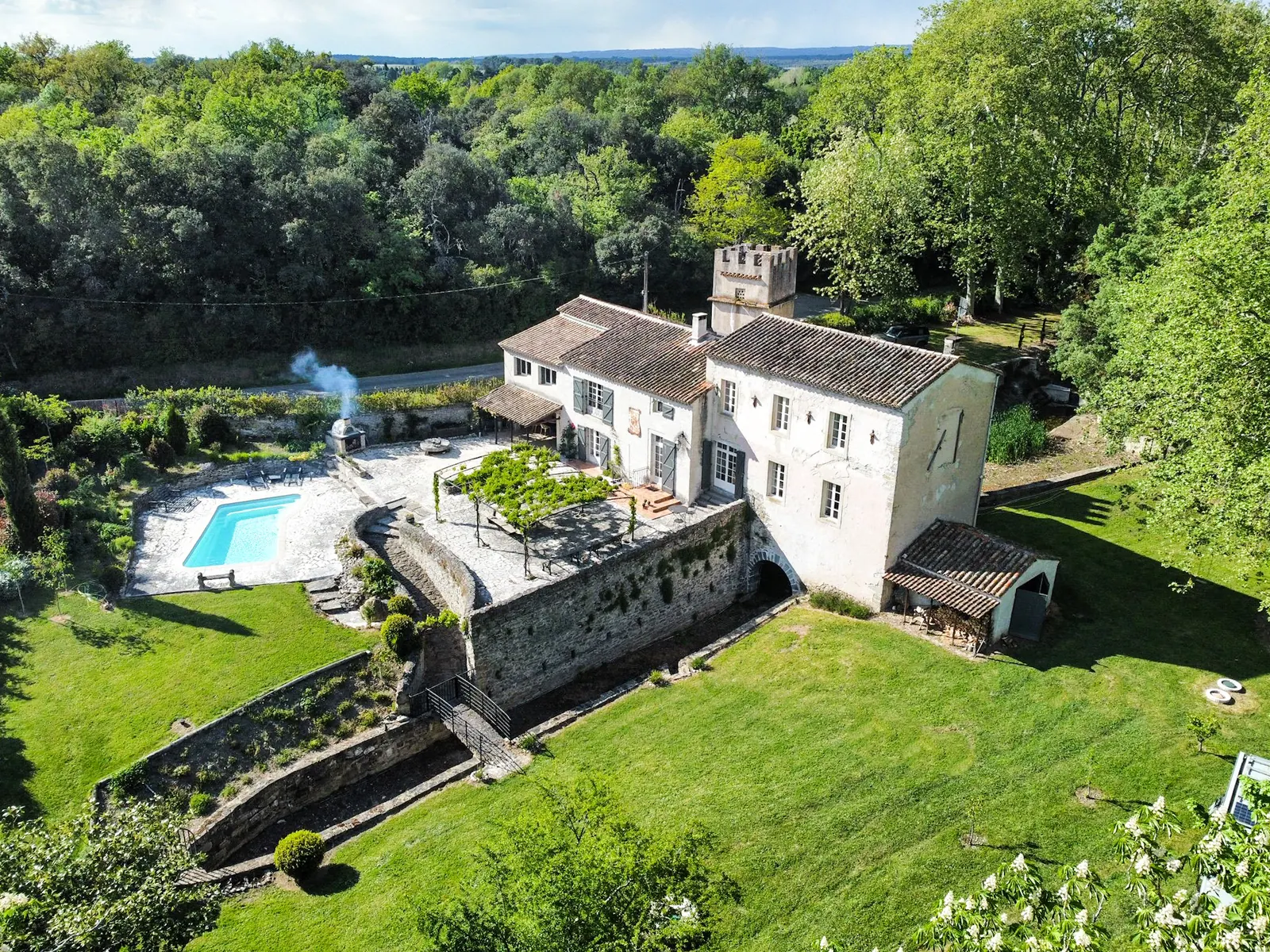 Le Moulin d’Alzau van boven: het huis, de terrassen, het zwembad en het gras eromheen.