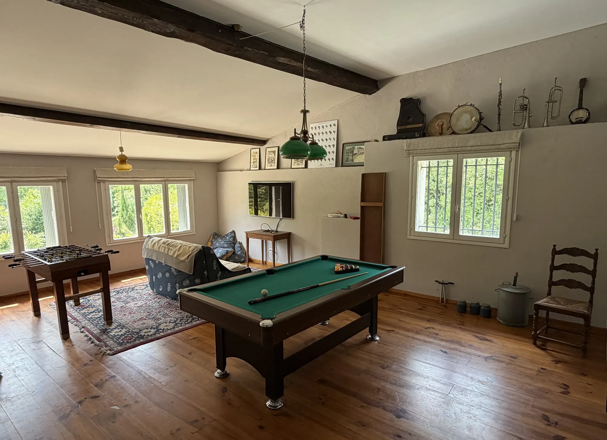 De speelkamer met een biljart en een tafelvoetbalspel onder de balken.